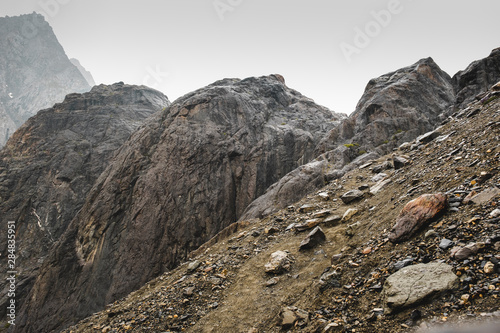 A sloping slope covered with loose stones. Difficult climb to Aktru. Beautiful views of the rounded mountains on a tour of the nature of Altai land. High pyramidal mountain. Siberia. Russia.