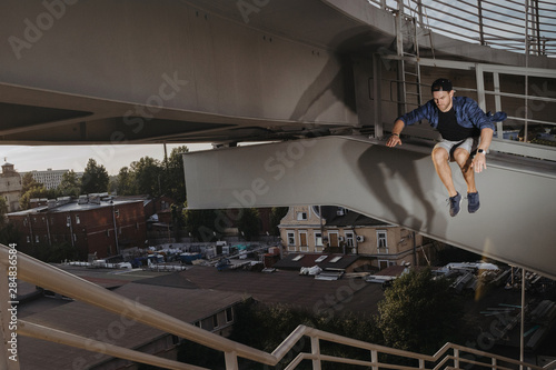 Freerun athlete doing scary jump from high bridge © Arsenii