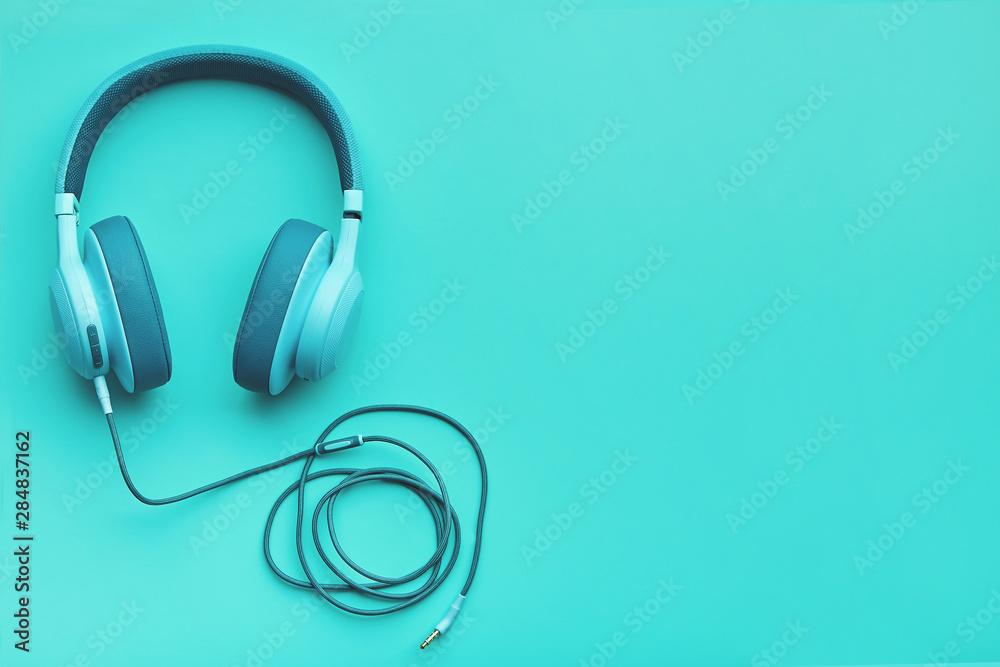Turquoise headphones on a colored background. Music concept with copyspace. Colored headphones isolated Turquoise headphones on a colored background. Music concept with copyspace. Colored headphones isolated