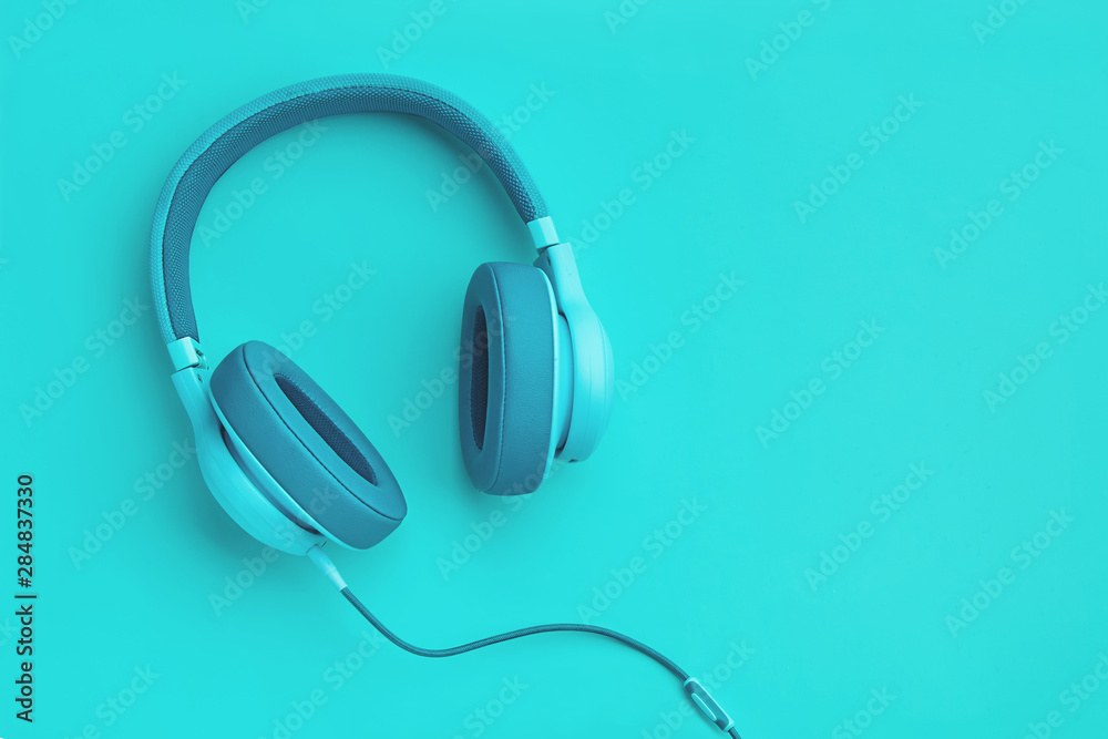 Turquoise headphones a colored background. Music concept with copyspace. Blue headphones isolated Turquoise headphones a colored background. Music concept with copyspace. Blue headphones isolated