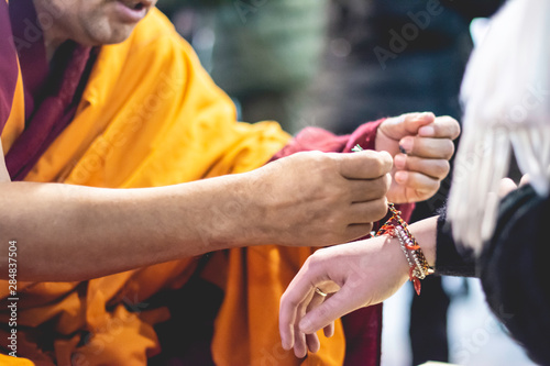 Buda poniendo cuerdas en mano, brazalete © Jose Cruz