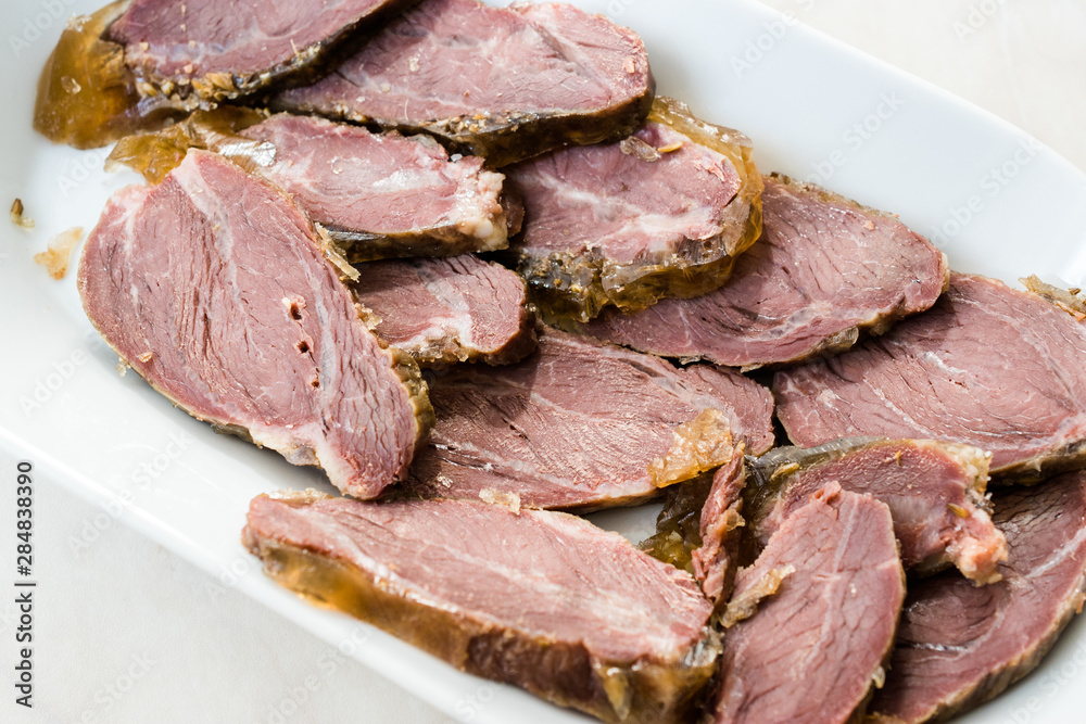 Smoked Meat Veal Cheek Slices on Wooden Board. Ready to Eat. Smoked Meat Veal Cheek Slices on Wooden Board. Ready to Eat.