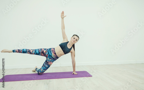 sports woman holds the bar in the fitness room. yoga and harmony