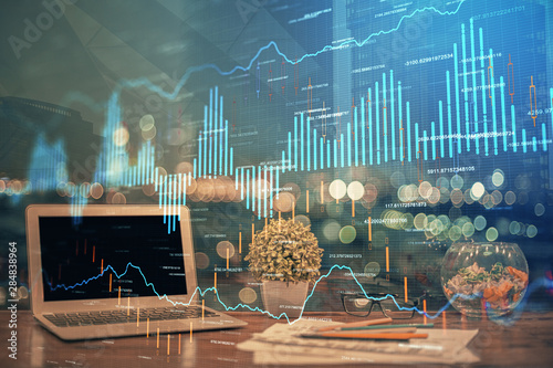 Double exposure of chart and financial info and work space with computer background. Concept of international online trading.