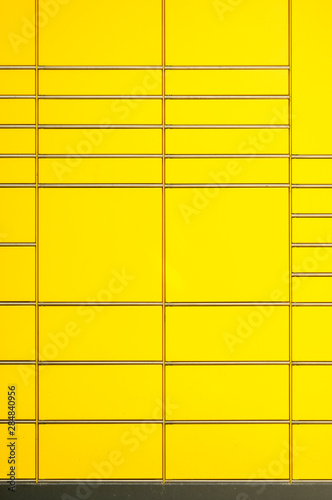 Ausschnitt einer Paketstation in Deutschland, die Linien der verchromten Leisten der unterschiedlich großen Fächer bilden ein abstraktes Muster mit Unterbrechungen als Hintergrund