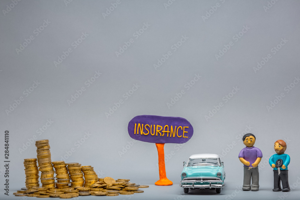 Purple insurance sign in between a pile of coins and a light blue car figurine and two plasticine figurines one with a car key, on gray background.