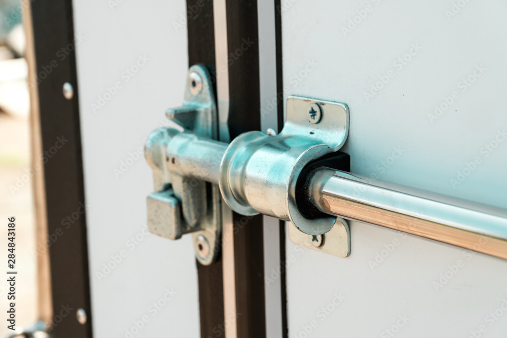 Photograph of a metal lock on a white door