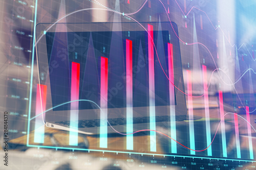 Stock market graph and table with computer background. Double exposure. Concept of financial analysis. © peshkova