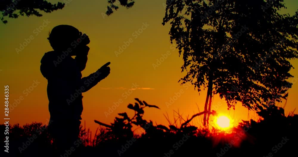 Boy shows class, thumbs up silhouette shot against the backdrop of the setting sun. Boy shows class, thumbs up silhouette shot against the backdrop of the setting sun.