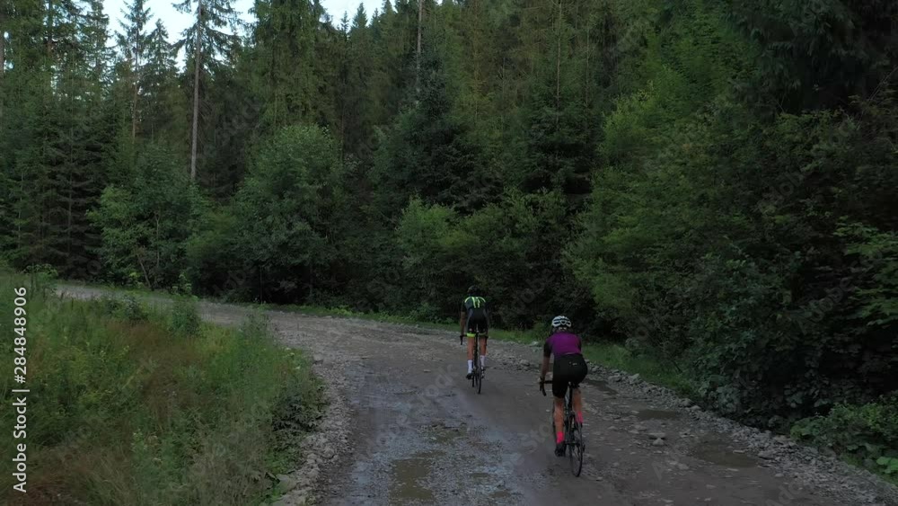 Two cyclists in beautiful mountain countryside. Aerial 4k shot Two cyclists in beautiful mountain countryside. Aerial 4k shot