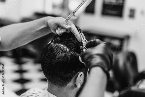 Man haircut in barbershop. Black and white photo. Retro style.
