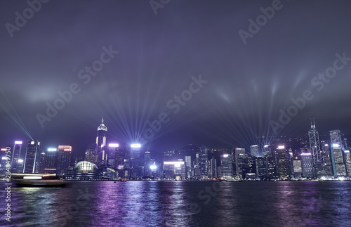 Light show in the sky over skyscrapers in Hong Kong at night