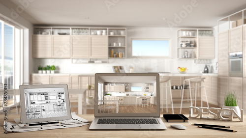 Architect designer desktop concept, laptop and tablet on wooden desk with screen showing interior design project and CAD sketch, blurred draft in the background, modern white kitchen