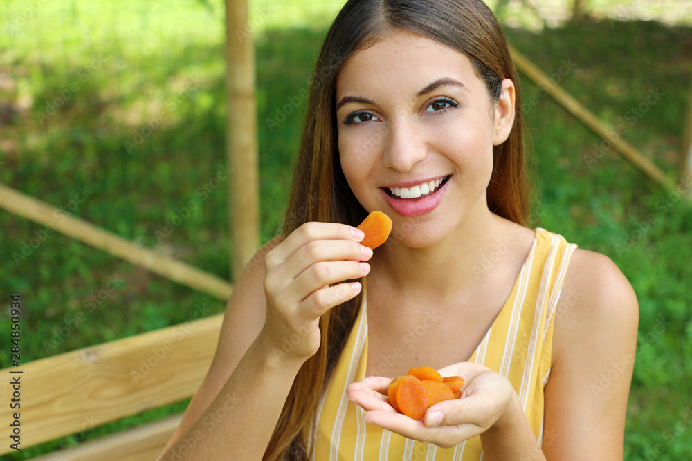 Young woman eating dried fruits in the park. Healthy food concept. Young woman eating dried fruits in the park. Healthy food concept.