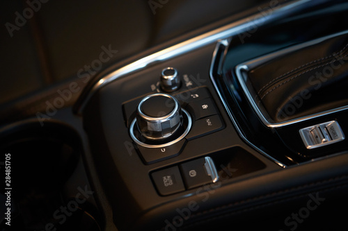 Vehicle interior of a modern car with media and navigation control buttons © jamesteohart