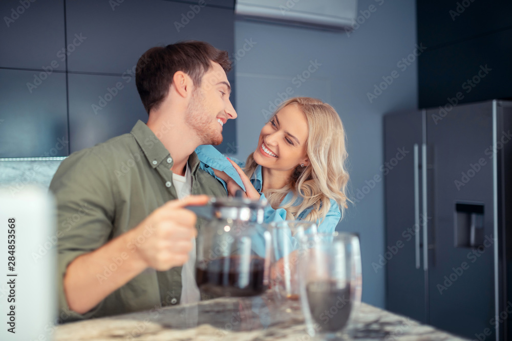 Couple smiling while enjoying morning at home together Couple smiling while enjoying morning at home together