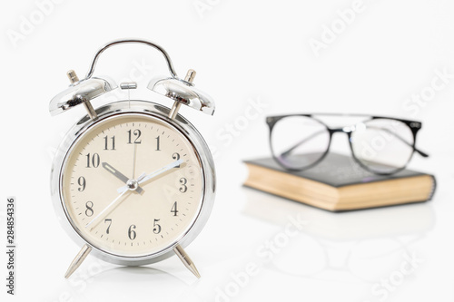 Silver alarm clock with old books