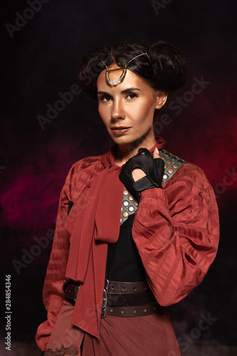 attractive steampunk woman looking at camera in smoke on black