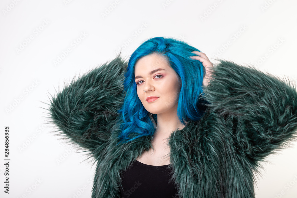 Animal protection, fashion and hair concept - beautiful girl dressed in artificial fur coat with blue hair standing on white background Animal protection, fashion and hair concept - beautiful girl dressed in artificial fur coat with blue hair standing on white background