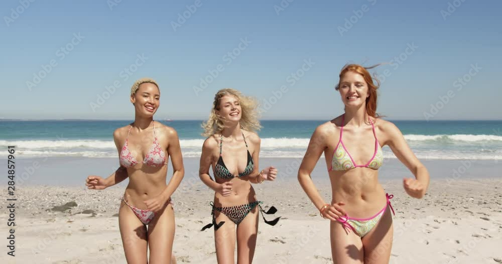 Young adult female friends running at the beach 4k Young adult female friends running at the beach 4k