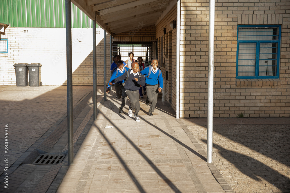 Schoolchildren running out into the playground at a township school