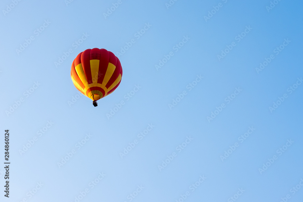 Red and yellow balloon flying in the blue sky Red and yellow balloon flying in the blue sky