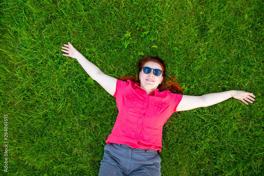 Portrait of a smiling red-haired young girl on green grass Portrait of a smiling red-haired young girl on green grass