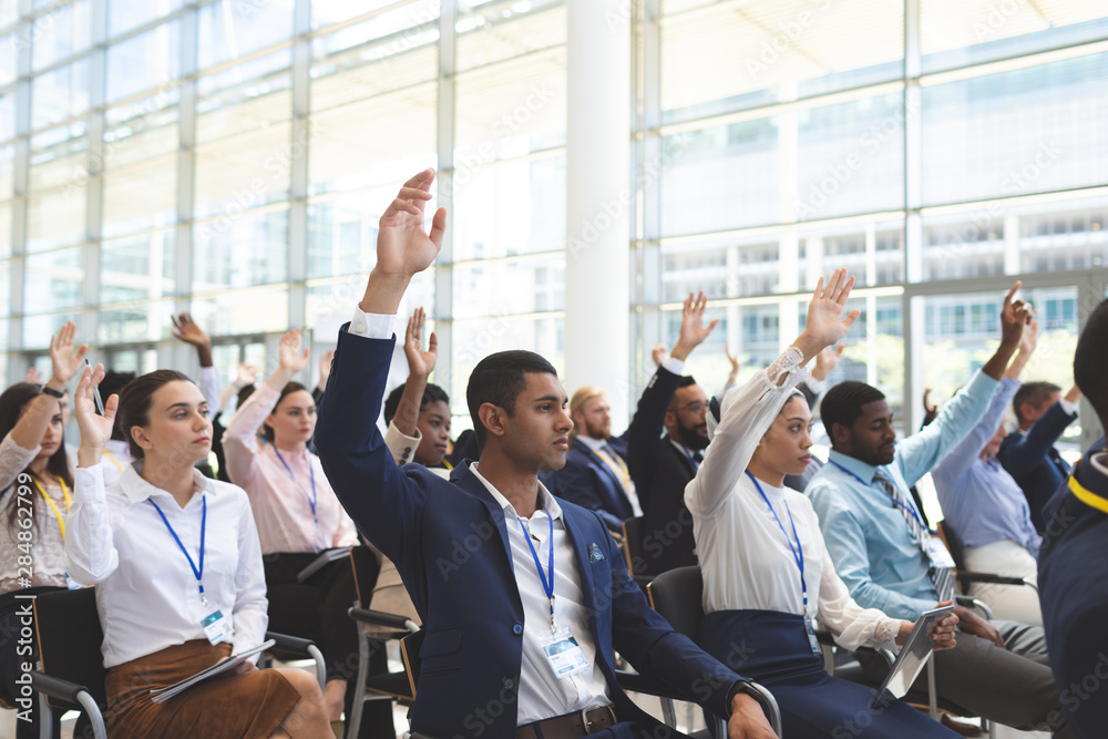 Business people raising hands in business seminar Business people raising hands in business seminar