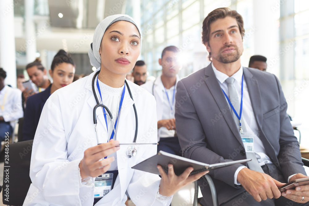 Female doctor with businessman attending seminar Female doctor with businessman attending seminar