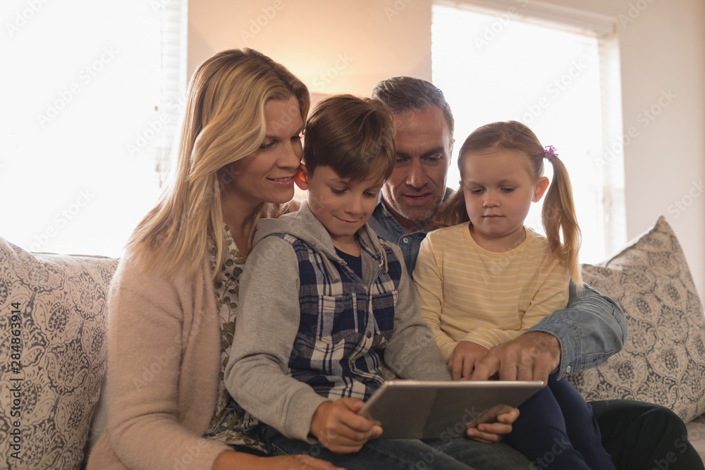 Fototapeta premium Family using digital tablet together in living room