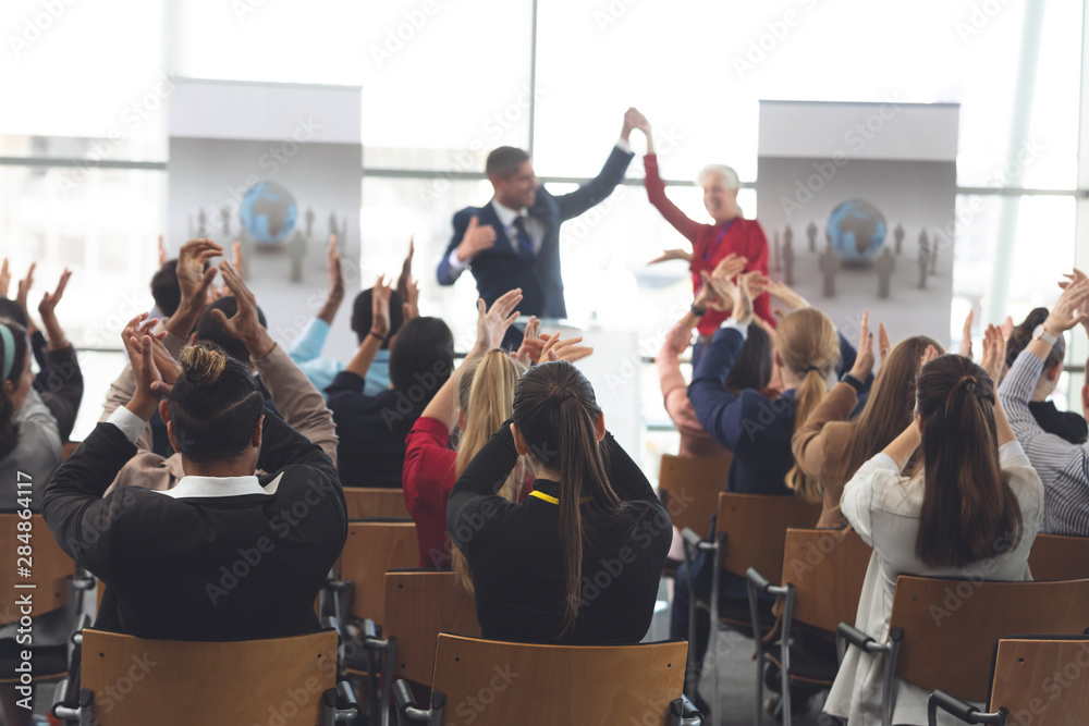 Naklejka premium Business people applauding and celebrating in a business seminar