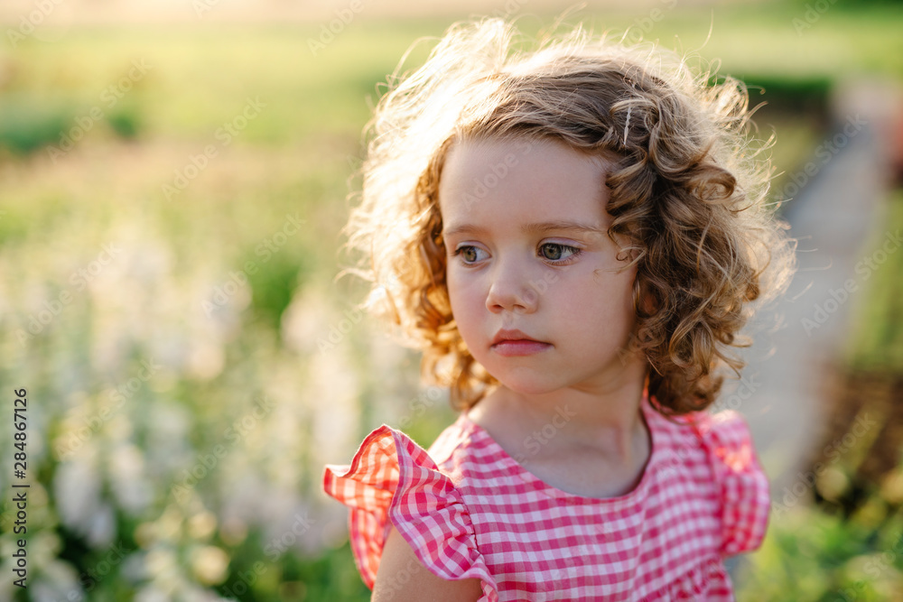 Portrait of small girl standing in the backyard garden. Portrait of small girl standing in the backyard garden.