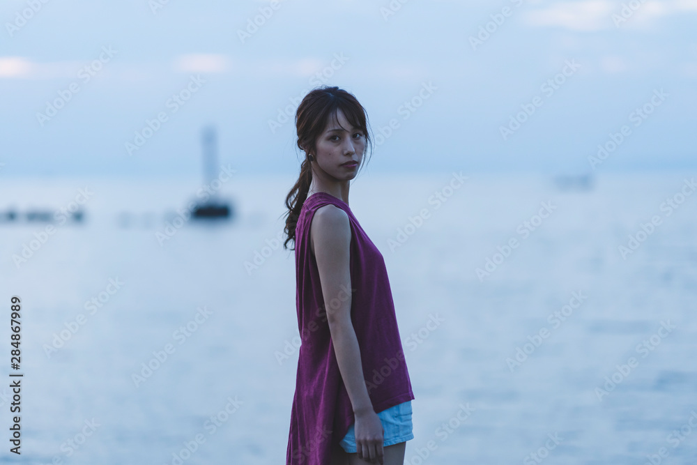 夕暮れの海の女性