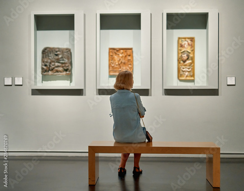 visitor looking art object in museum