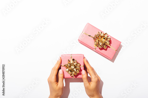 Gift boxes packed in pink paper with golden bows