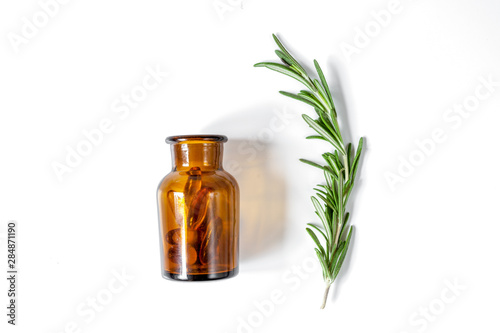 fresh rosemary with bottle on white background top view