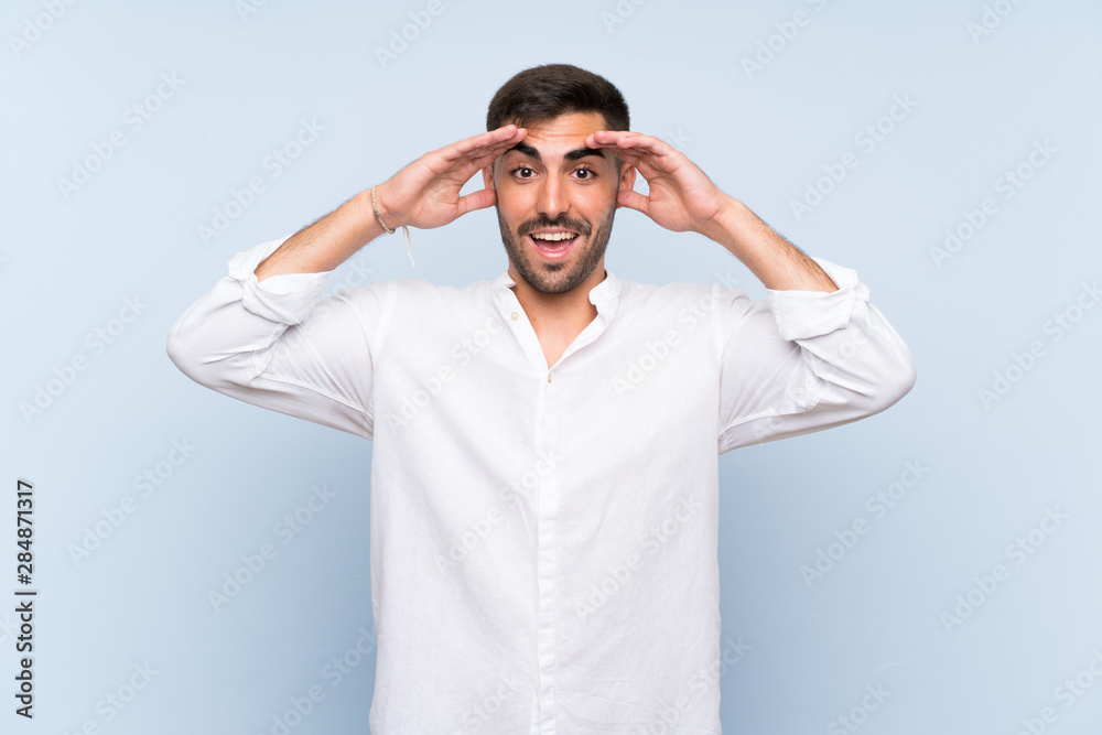 Handsome man with beard over isolated blue background with surprise expression Handsome man with beard over isolated blue background with surprise expression