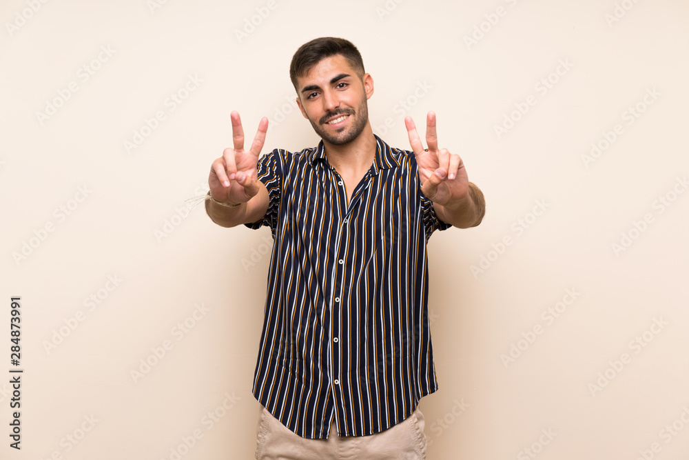 Handsome man with beard over isolated background smiling and showing victory sign Handsome man with beard over isolated background smiling and showing victory sign