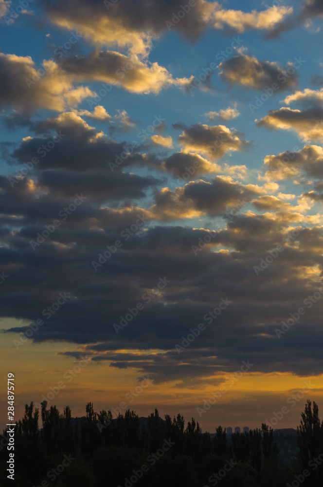 Landscape with dramatic light - beautiful golden sunset with saturated sky and clouds.