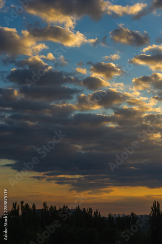 Landscape with dramatic light - beautiful golden sunset with saturated sky and clouds.