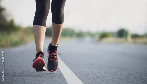 Young woman runner running on city bridge road. Young fitness woman runner athlete running on the road in the morning