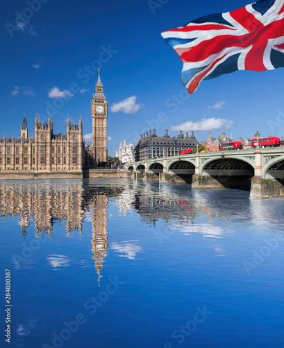 Big Ben and Houses of Parliament with red buses on the bridge in London, England, UK