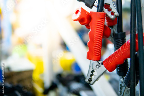 Jumper cable for rechanging car battery. Fixing tools or mechanical equipment in auto repair garage. photo