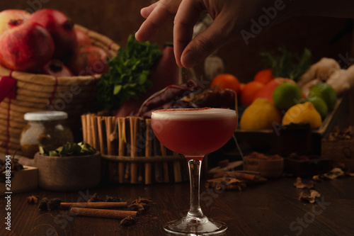 Beautiful cocktail in the chalet on a wooden background. Background decorated with fruits and herbs.
