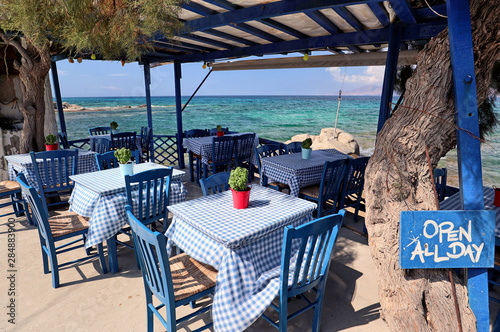 Typical blue furniture Greek taverna by a turquoise Aegean Sea, Agios Prokopios, Naxos, Greek Islands