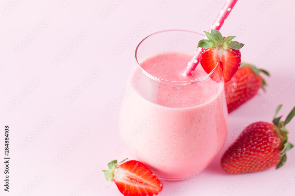 A glass of fresh strawberry smoothie on a wooden background. Summer drink shake, milkshake, juice and refreshment organic concept.