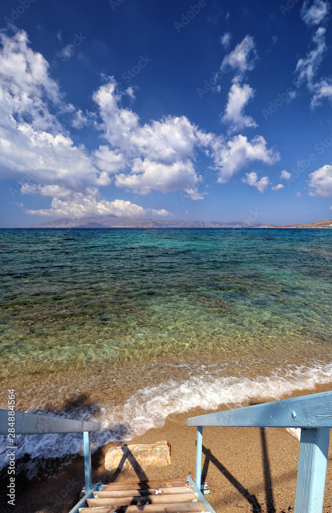 Blue steps down to sandy beach and turquoise Aegean Sea, Agios Prokopios, Naxos, Greek Islands