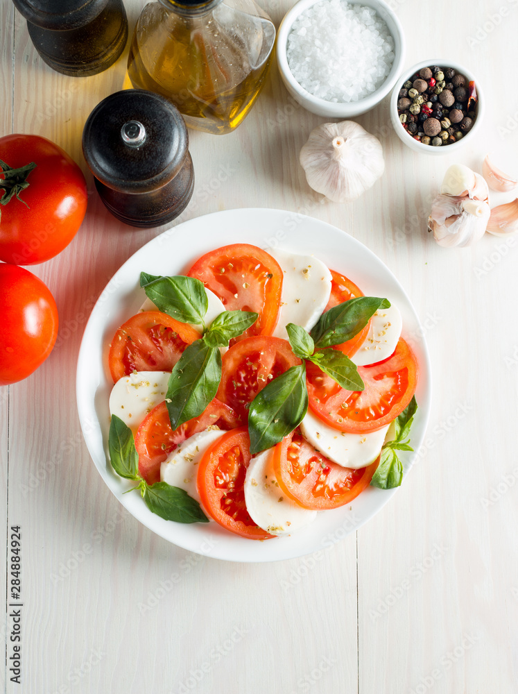Close-up photo of caprese salad with ripe tomatoes, basil, buffalo mozzarella cheese. Italian and Mediterranean food concept. Fresh and healthy organic meal. Starter and antipasti.