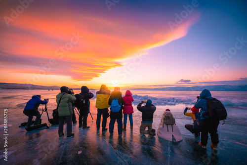 Photographers or Travellers using a professional DSLR camera take photo beautiful landscape of Baikal lake at sunset winter, Rusia - Recreation and outdoor travel concept.