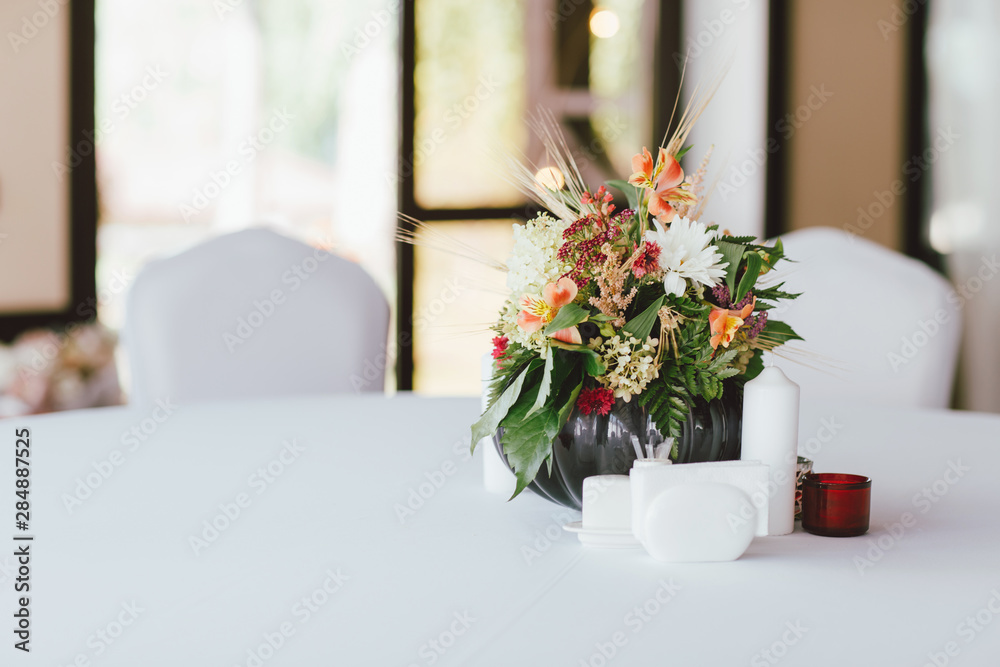 Bouquet of different flowers in a vase on table, preparing for event, wedding